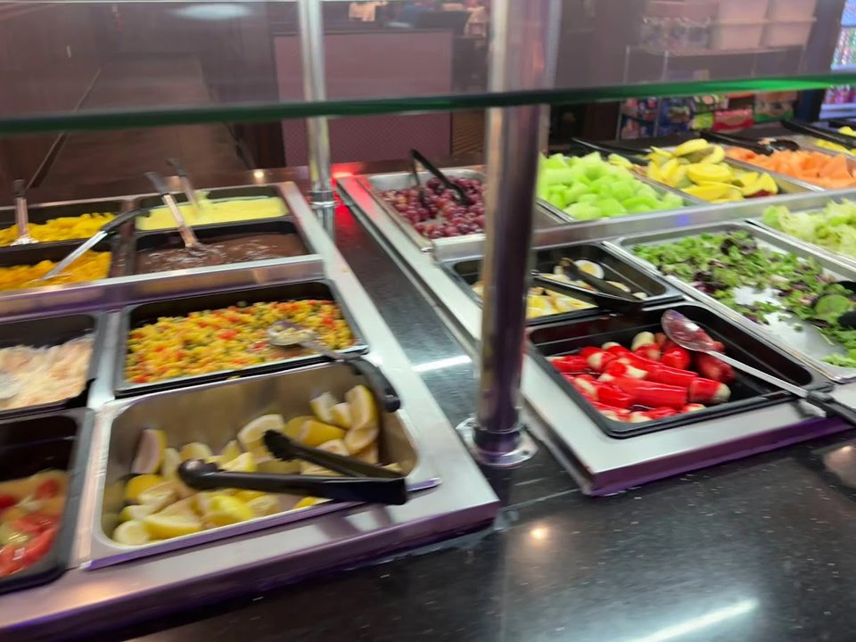 Dessert case beside a busy buffet line